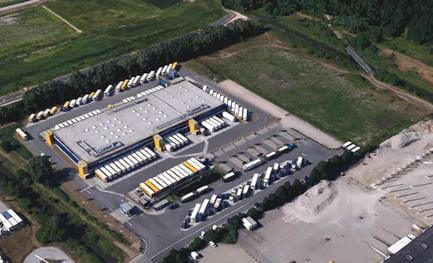 Baufortschritt des neuen Logistikzentrums in Hamburg mit sichtbarem Rohbau und Baustellenfahrzeugen.